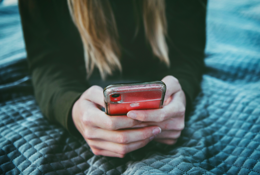 pige med telefon i hånden