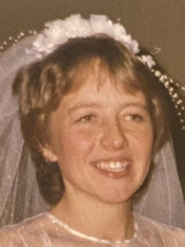 Alice på sin brudedag. Hun har et brudeslør i håret og et stort smil.