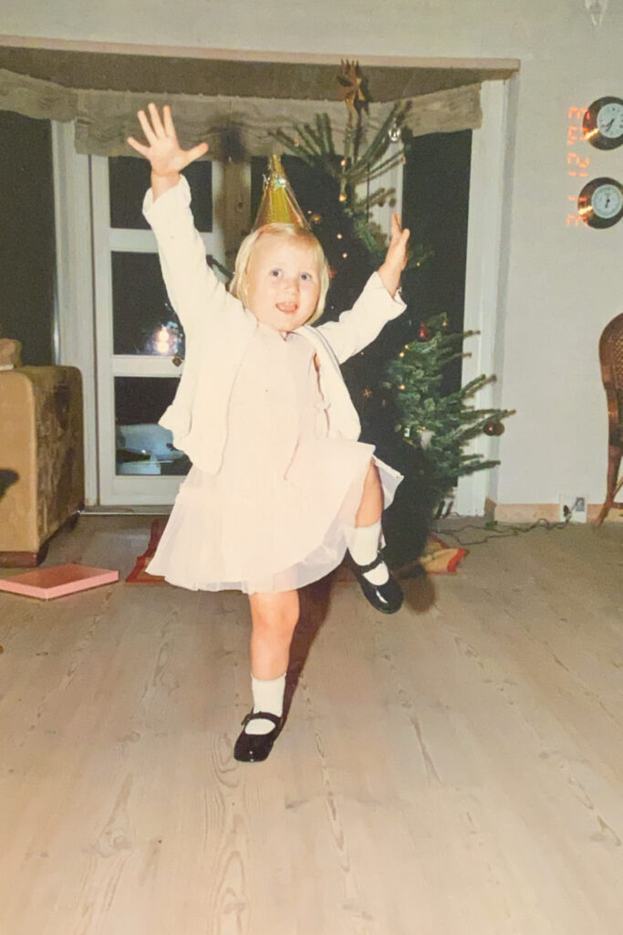 Victoria Skjoldan som barn. Danser rundt foran juletræet