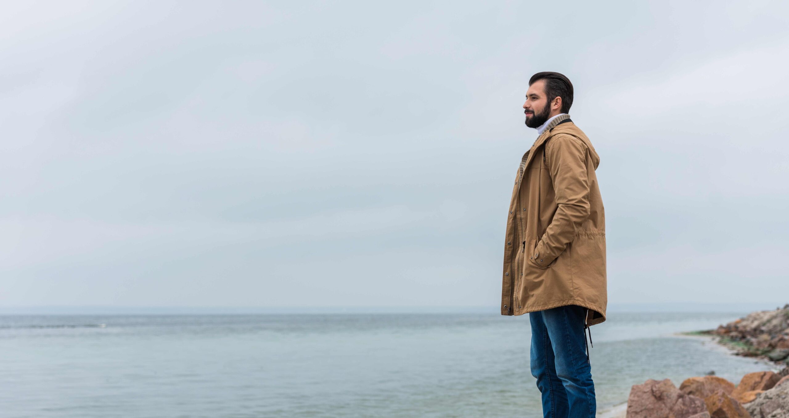 Mand på en strand - kigger over havet