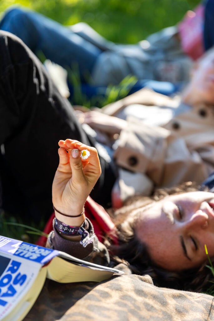 En hånd holder en lille hvid blomst